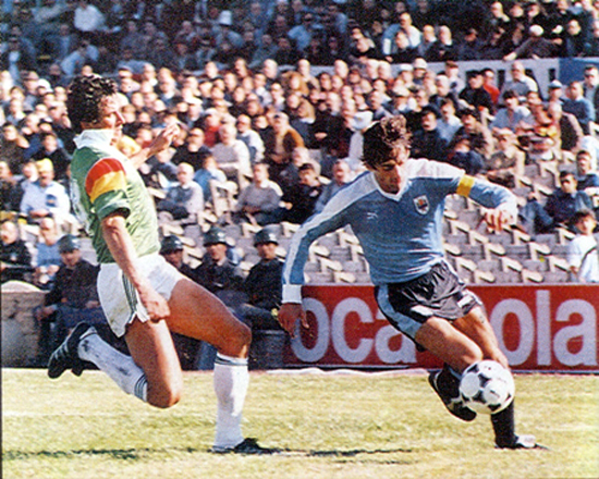 Enzo Francéscoli enfrenta a Eligio Martínez en el partido que Uruguay derrotó a Bolivia por 2 a 0. Hasta ese partido Bolivia podía clasificar. El resultado nos sacó. Iguales en puntos, por debate en gol diferencia.