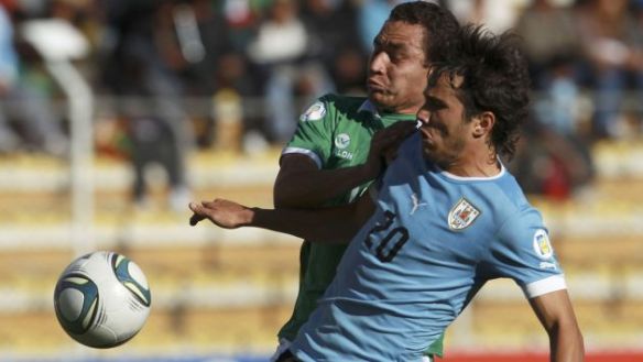 Uruguay's Alvaro Gonzalez, right, battles for the ball with Bolivia's Gualberto Mujica during a 2014 World Cup qualifying soccer match in La Paz, Bolivia, Tuesday, Oct. 15, 2012. (AP Photo/Juan Karita)
