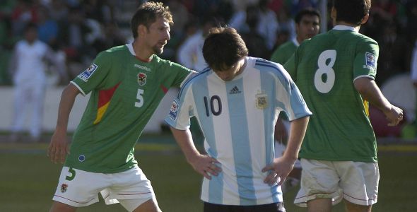 Argentina's Lionel  Messi reacts as Bolivia's Ronald Rivero and Ronald Garcia celebrate a goal during their 2010 World Cup qualifying soccer match in La Paz